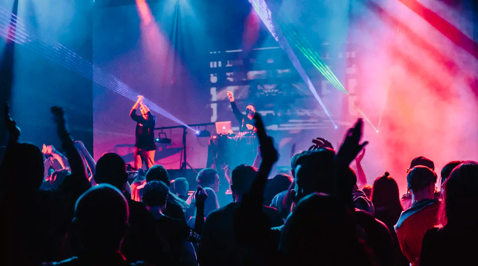 Concert sous les lasers, foule les bras levés